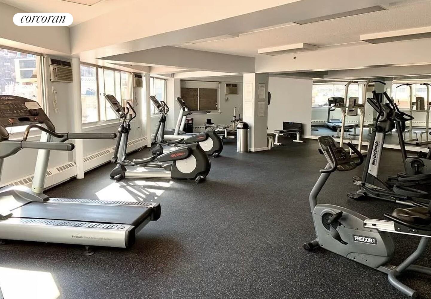 300 West 145th Street, Unit 1K Manhattan, NY 10039 - Photo 21 of 28 a room with gym equipment and large mirror