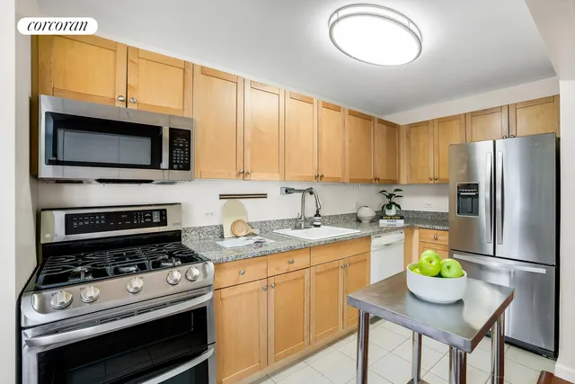 a kitchen with stainless steel appliances granite countertop a stove refrigerator and a microwave