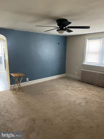 a view of a livingroom with a ceiling fan and window