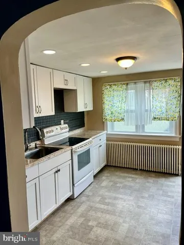 a kitchen with white cabinets and white appliances