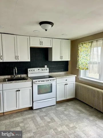 a kitchen with white cabinets and white appliances