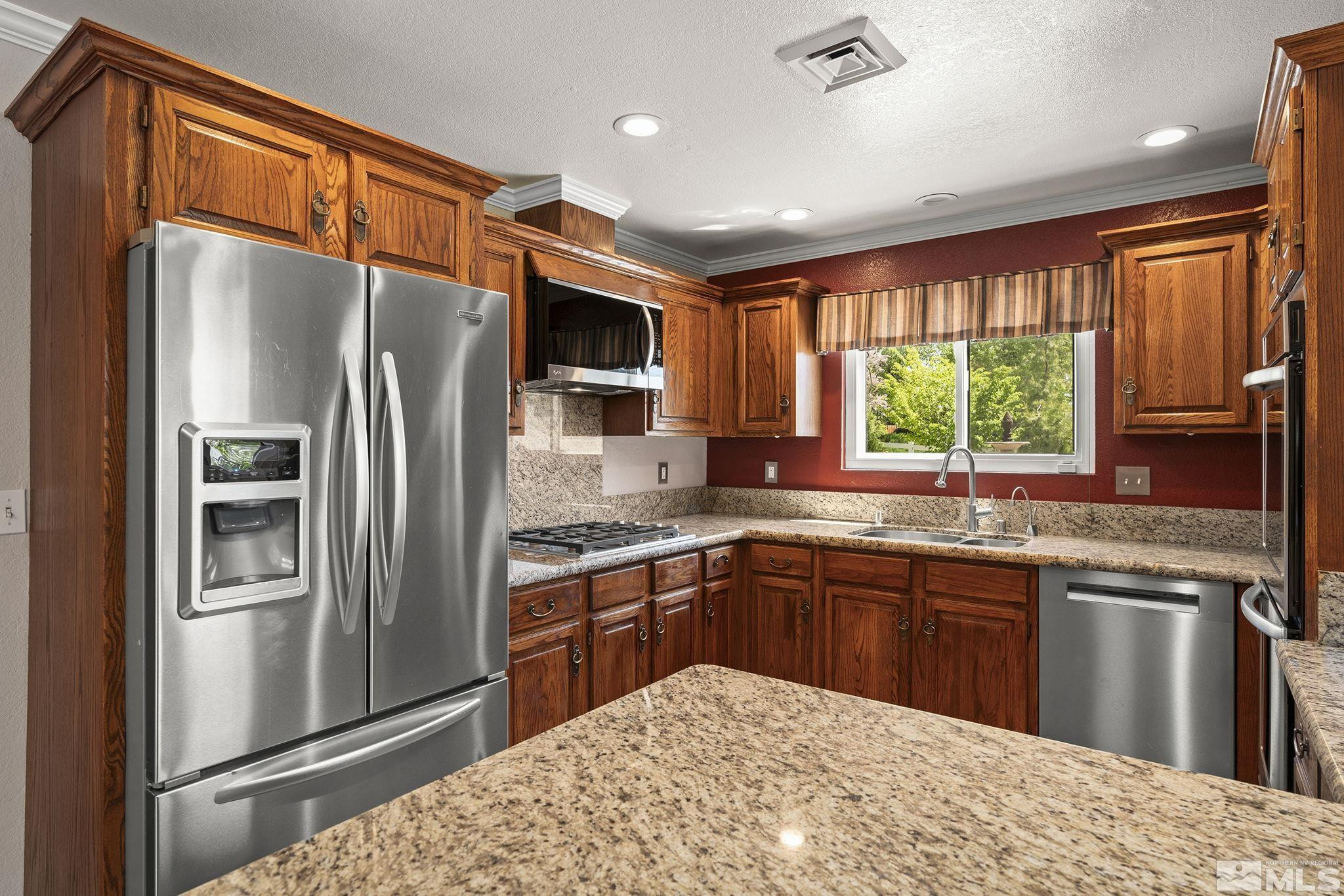 930 Spanish Springs Road Sparks, NV 89434 - Photo 21 of 40 a kitchen with granite countertop stainless steel appliances a refrigerator sink and microwave