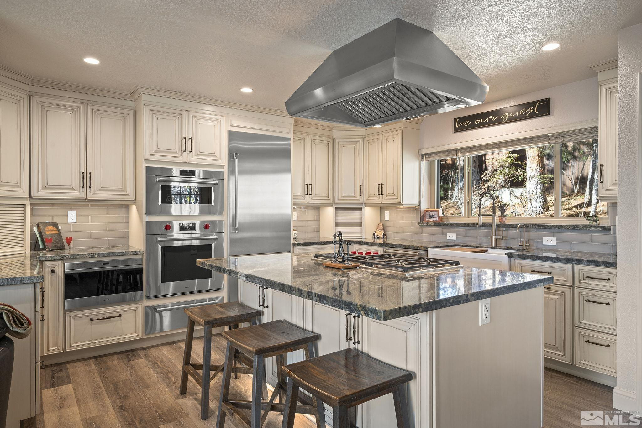 930 Spanish Springs Road Sparks, NV 89434 - Photo 29 of 40 a kitchen with stainless steel appliances granite countertop a stove top oven a sink refrigerator and cabinets