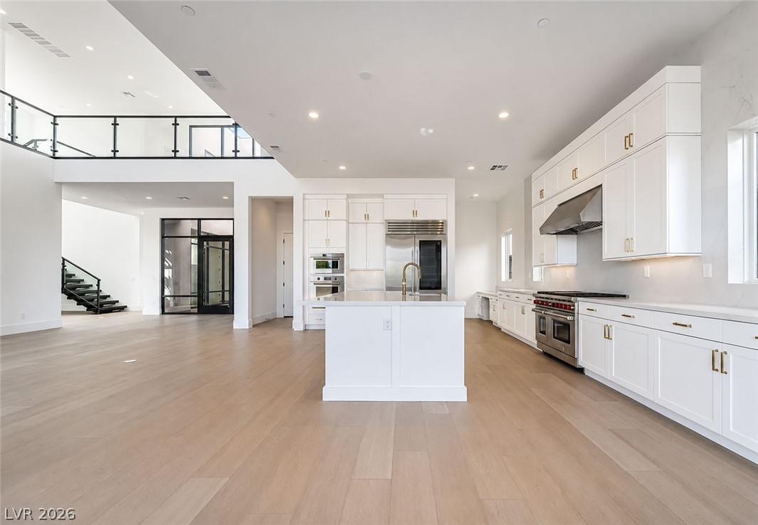 4846 Shady Rdg Drive Las Vegas, NV 89135 - Photo 3 of 60 An open-concept living space highlights a sophisticated kitchen island and gleaming hardwood floors.