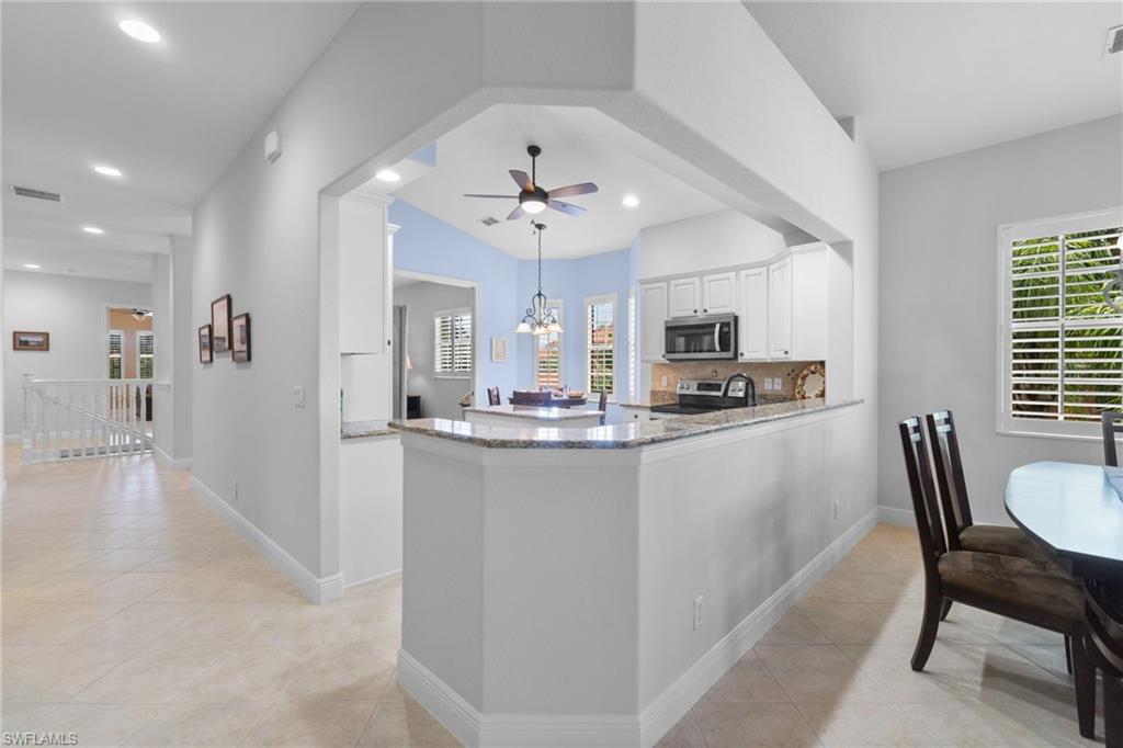 6414 Legacy Circle, Unit 903 Naples, FL 34113 - Photo 16 of 50 a kitchen with kitchen island granite countertop a sink and a refrigerator