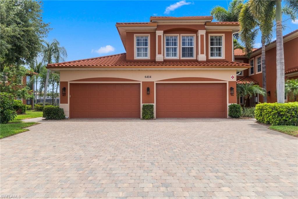 6414 Legacy Circle, Unit 903 Naples, FL 34113 - Photo 3 of 50 a front view of a house with a yard and garage