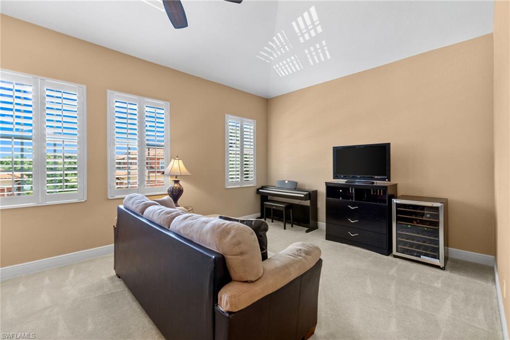 6414 Legacy Circle, Unit 903 Naples, FL 34113 - Photo 33 of 50 a living room with furniture and a flat screen tv