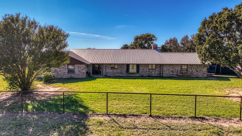 1003 Lamkin Road Mineral Wells, TX 76067 - Photo 2 of 40 Ranch-style home with a metal roof and brick siding