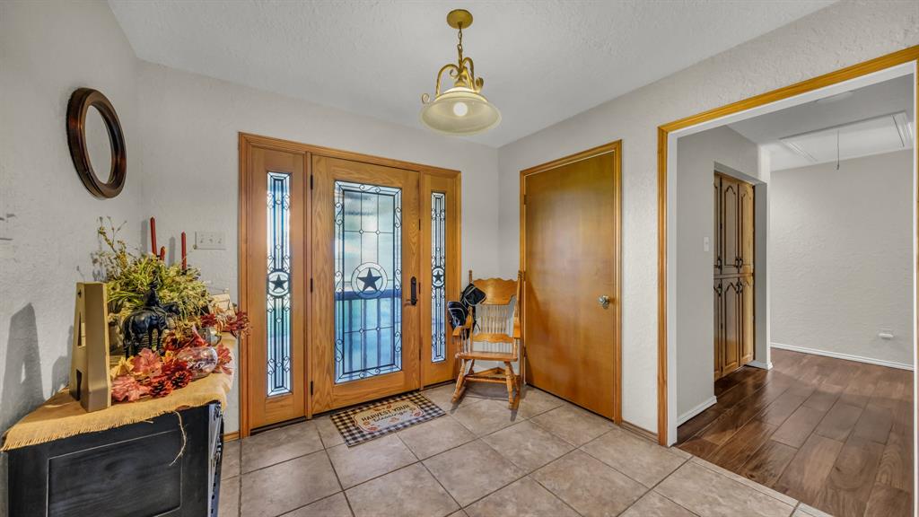 1003 Lamkin Road Mineral Wells, TX 76067 - Photo 3 of 40 Foyer entrance featuring a textured wall and tile patterned flooring
