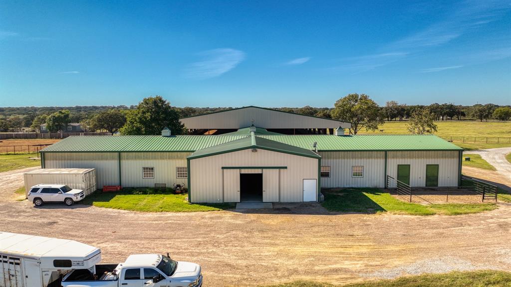 1003 Lamkin Road Mineral Wells, TX 76067 - Photo 36 of 40 Rear view of property featuring an outbuilding, a metal roof, and a view of countryside