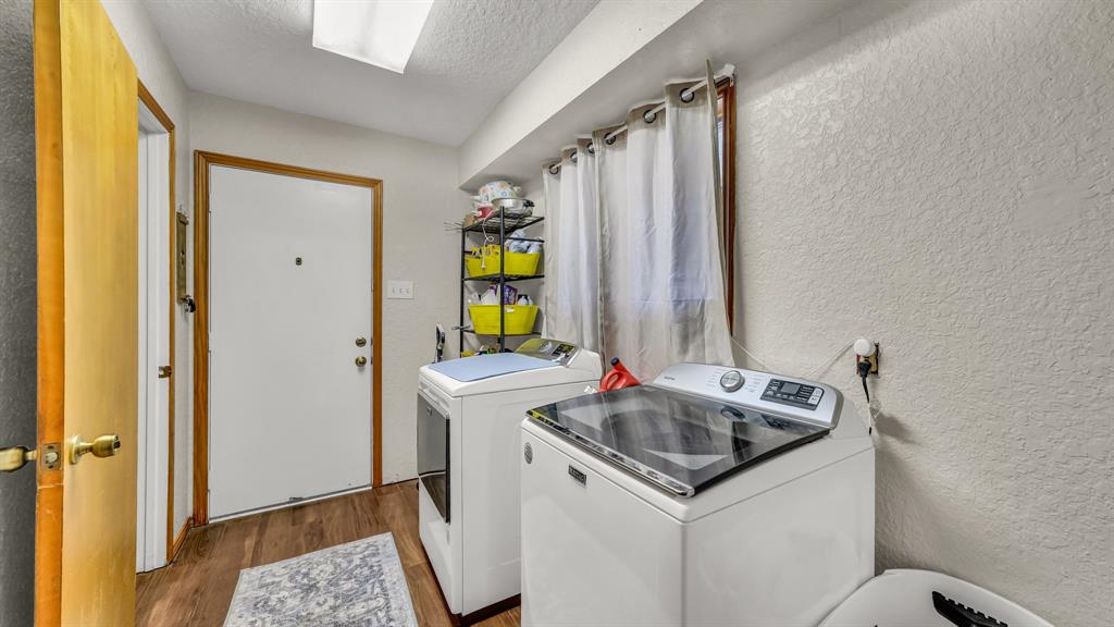 1003 Lamkin Road Mineral Wells, TX 76067 - Photo 7 of 40 Washroom with a textured wall, dark wood-style flooring, a textured ceiling, and washing machine and dryer