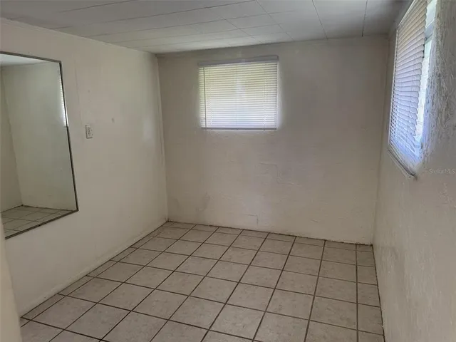 an empty room with white walls and tiles