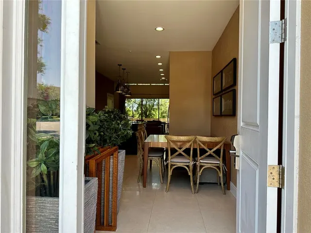 a dining room with furniture and a floor to ceiling window