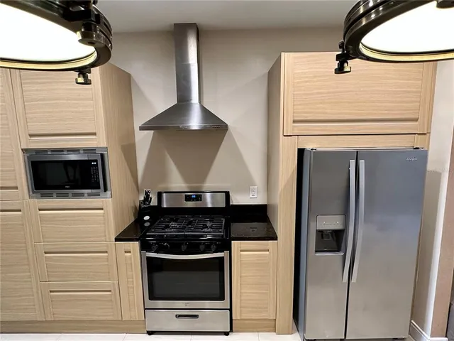 a kitchen with granite countertop a sink stainless steel appliances and cabinets