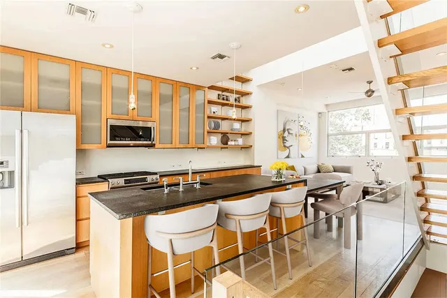 a kitchen with stainless steel appliances granite countertop a stove a sink and a microwave