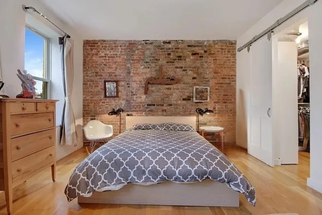 a bed sitting in a bedroom next to a book shelf