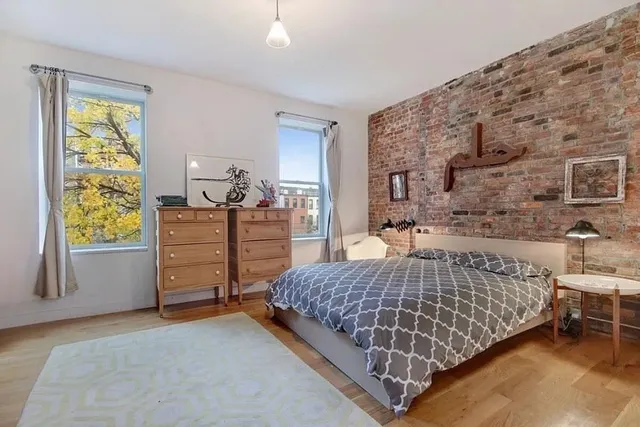 a large bed sitting in a bedroom next to a window and dresser