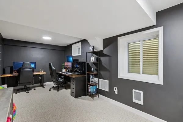 a view of a workspace with furniture and a window