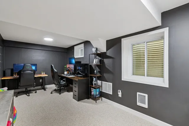 a view of a workspace with furniture and a window