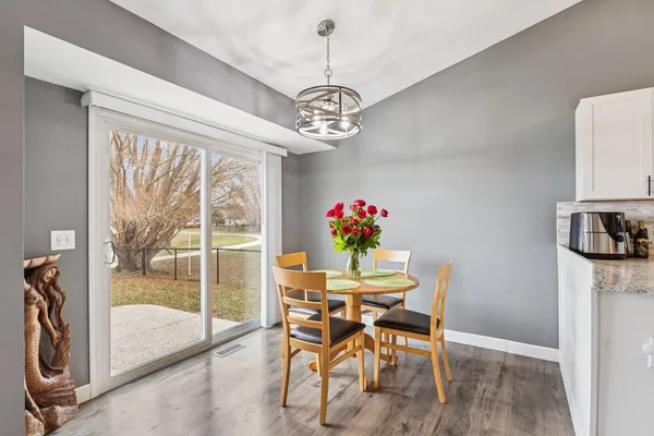 a dining room with furniture a chandelier and wooden floor