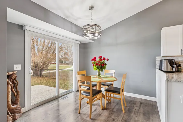 a dining room with furniture a chandelier and wooden floor