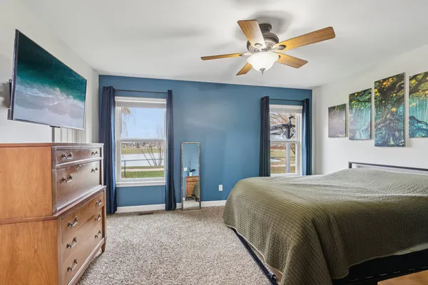 a bedroom with a bed and a large window