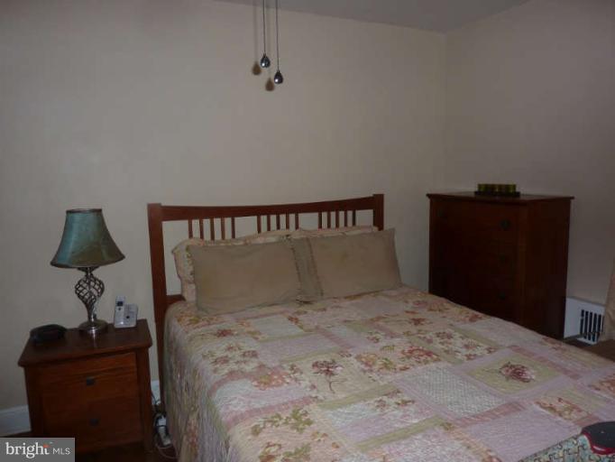 619 Stamford Road Baltimore, MD 21229 - Photo 8 of 17 a bedroom with a bed and a flat tv screen on dresser