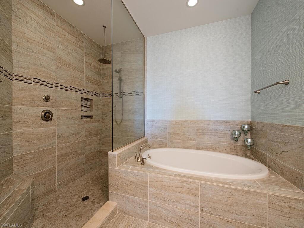 16444 Carrara Way, Unit 7301 Naples, FL 34110 - Photo 11 of 22 a white bath tub sitting next to a shower