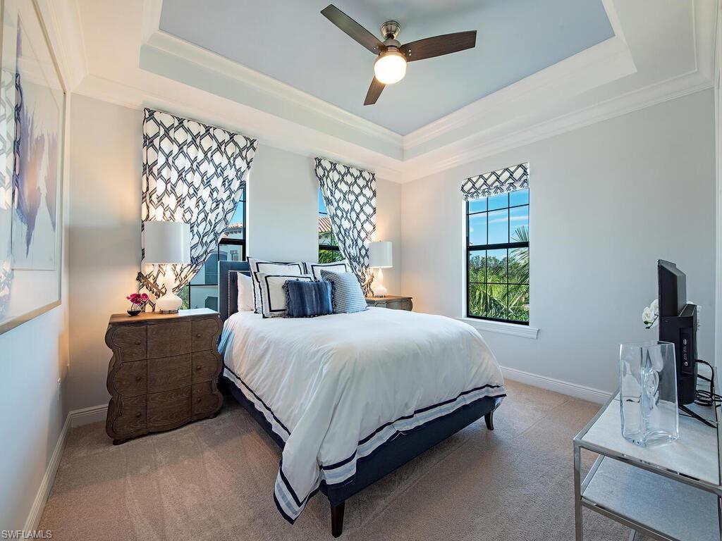 16444 Carrara Way, Unit 7301 Naples, FL 34110 - Photo 14 of 22 a bedroom with a bed window and a flat screen tv