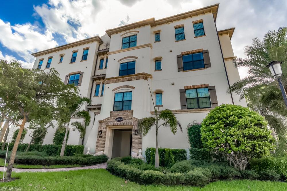 16444 Carrara Way, Unit 7301 Naples, FL 34110 - Photo 18 of 22 a front view of a multi story building with yard and green space