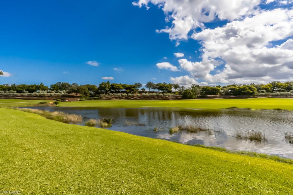 16444 Carrara Way, Unit 7301 Naples, FL 34110 - Photo 22 of 22 a view of a lake with houses in the background