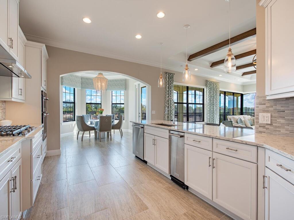 16444 Carrara Way, Unit 7301 Naples, FL 34110 - Photo 5 of 22 a large white kitchen with sink and cabinets