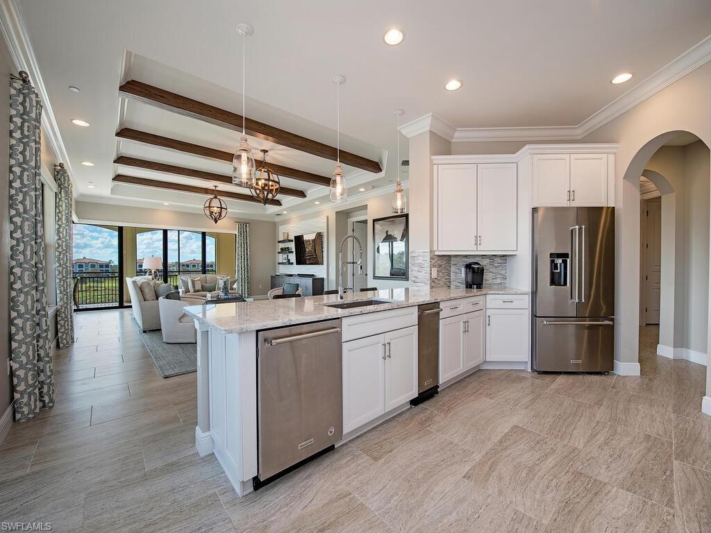 16444 Carrara Way, Unit 7301 Naples, FL 34110 - Photo 6 of 22 a kitchen with refrigerator and cabinets
