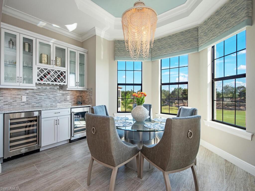 16444 Carrara Way, Unit 7301 Naples, FL 34110 - Photo 7 of 22 a dining room with furniture a chandelier and wooden floor