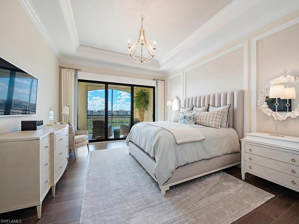16444 Carrara Way, Unit 7301 Naples, FL 34110 - Photo 8 of 22 a spacious bedroom with a large bed and a chandelier
