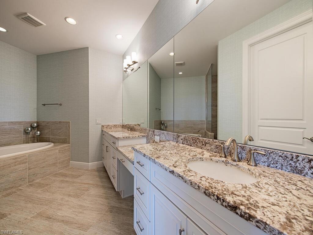 16444 Carrara Way, Unit 7301 Naples, FL 34110 - Photo 10 of 22 a bathroom with a granite countertop double vanity sink and a large mirror