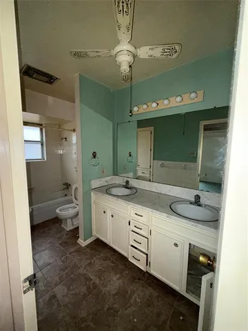 an empty room with windows and ceiling fan