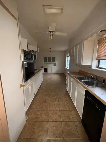 a large kitchen with granite countertop a stove and a sink
