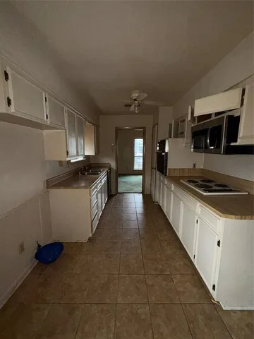 a view of an empty room with a kitchen