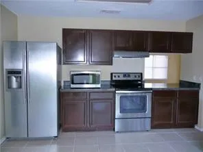 a kitchen with a refrigerator and a stove top oven