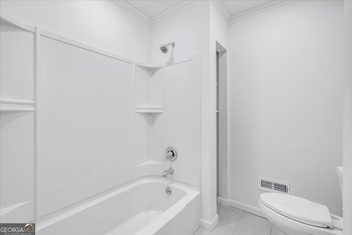 1806 Knox Street Dublin, GA 31021 - Photo 26 of 48 a bathroom with a bathtub and toilet