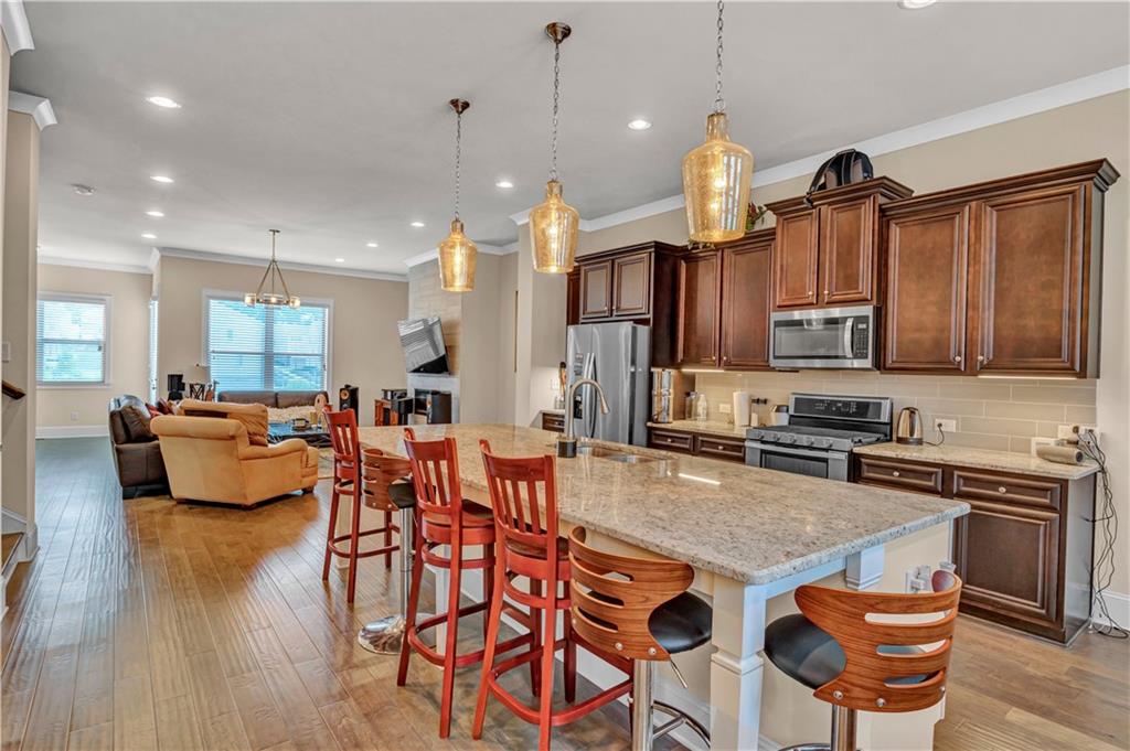2453 Soft Maple Street Doraville, GA 30360 - Photo 11 of 30 a kitchen with stainless steel appliances granite countertop a stove top oven a sink a dining table and chairs with wooden floor