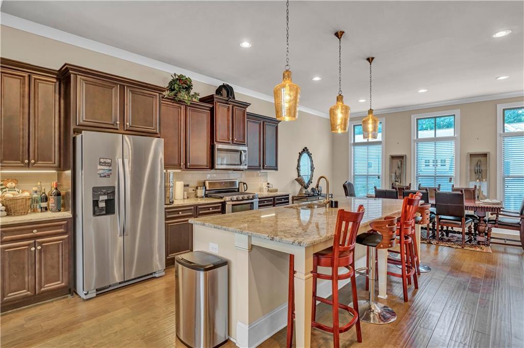 2453 Soft Maple Street Doraville, GA 30360 - Photo 12 of 30 a kitchen with stainless steel appliances a refrigerator a stove a sink a dining table and chairs with wooden floor