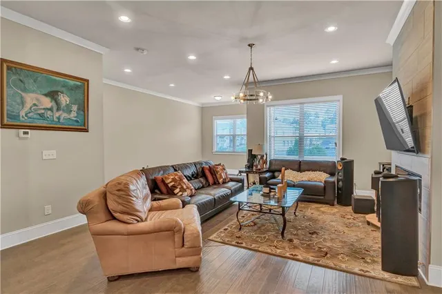 a living room with furniture a chandelier and a flat screen tv