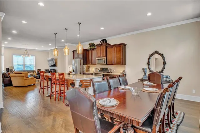 a dining room with stainless steel appliances kitchen island granite countertop a dining table chairs and view living room