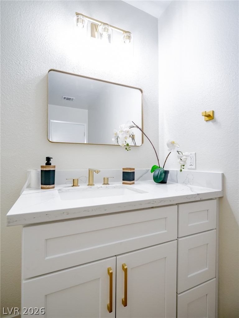 321 Lakehurst Road Las Vegas, NV 89145 - Photo 17 of 33 Gold hardware pairs with a quartz countertop and classic white cabinetry.