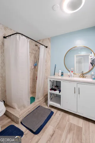 a living room with a mirror and a wooden floor