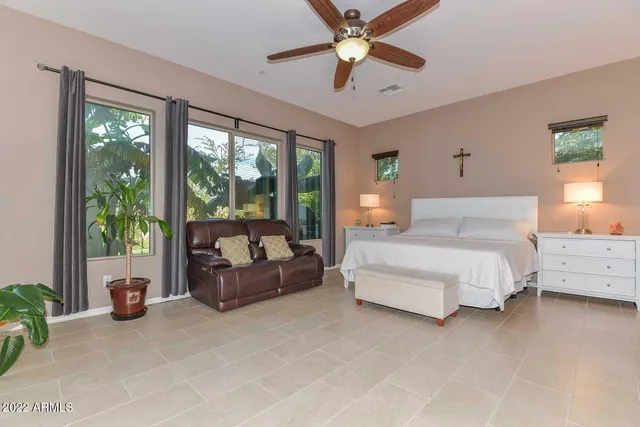 a bedroom with a bed couch and large window