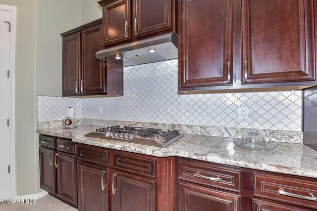 a kitchen with granite countertop cabinets and a stove top oven