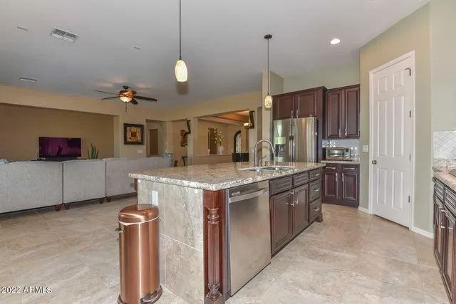 a kitchen with stainless steel appliances granite countertop a sink a stove and a refrigerator